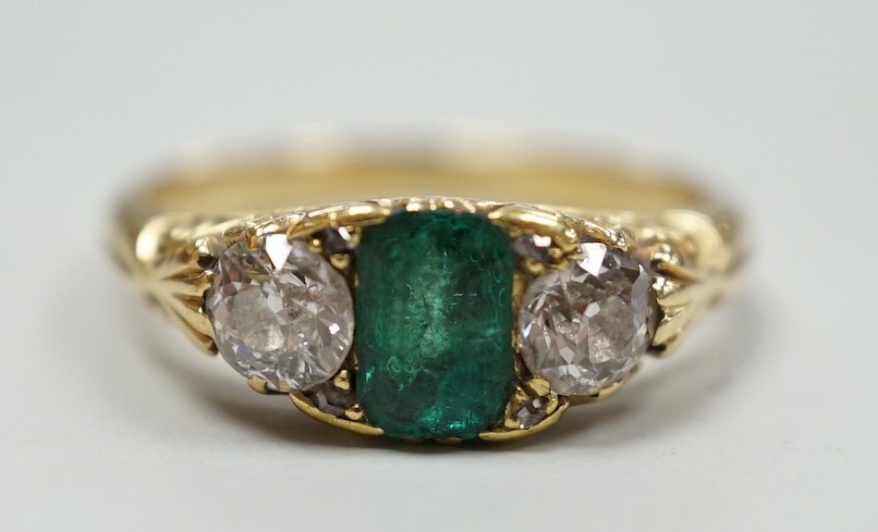 An early 20th century yellow metal, emerald and diamond set three stone ring, size L, gross weight 4.2 grams.